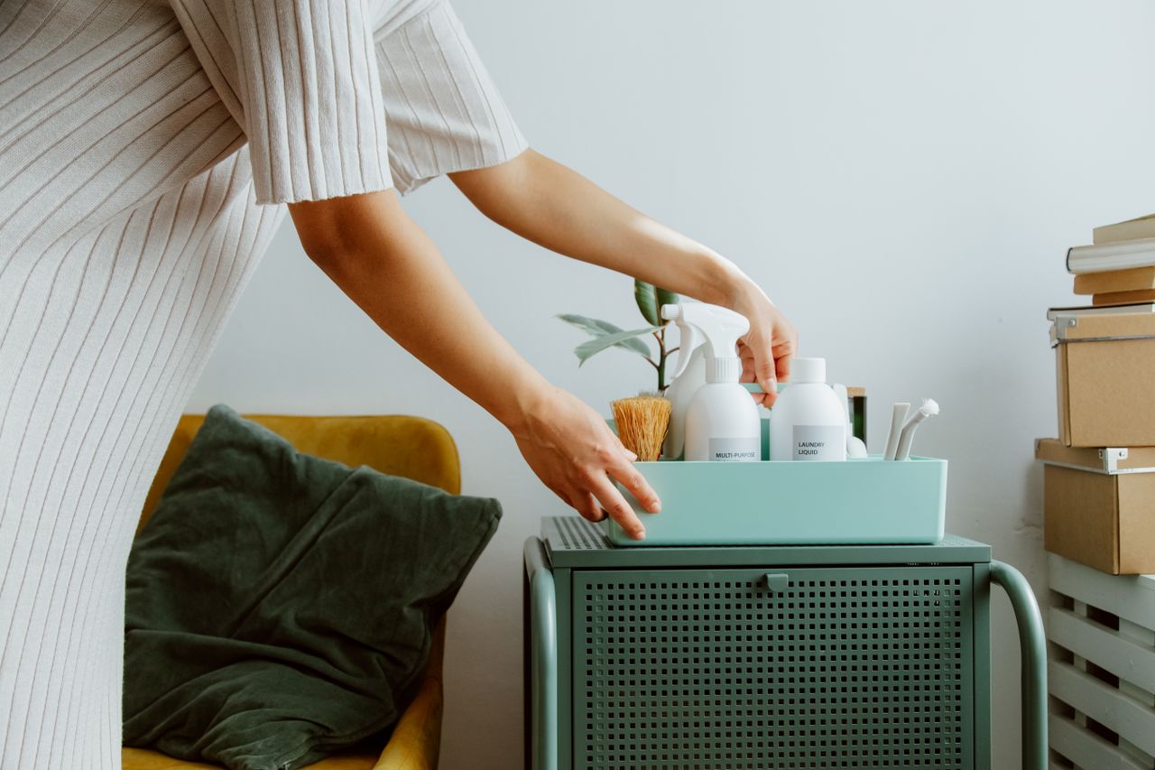 about-details A woman organizes self-care products in a stylish room, embodying minimalism and tranquility.