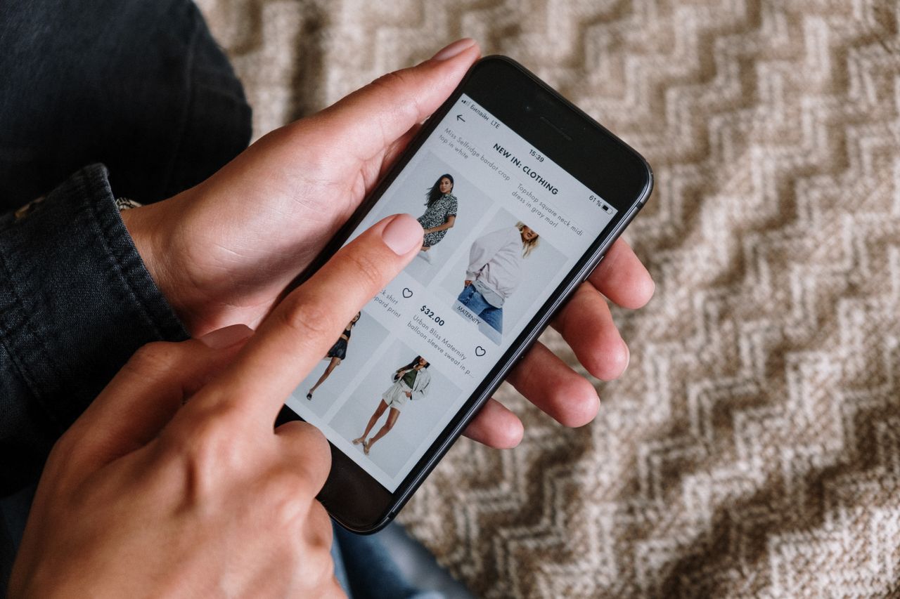 Mastering the First Impression: Your intriguing post title goes here Person browsing clothing items on a smartphone, showcasing modern online shopping experience.