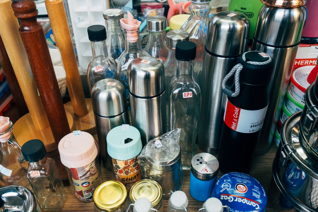 missions A variety of kitchen containers including bottles, jars, and thermos flasks on display.